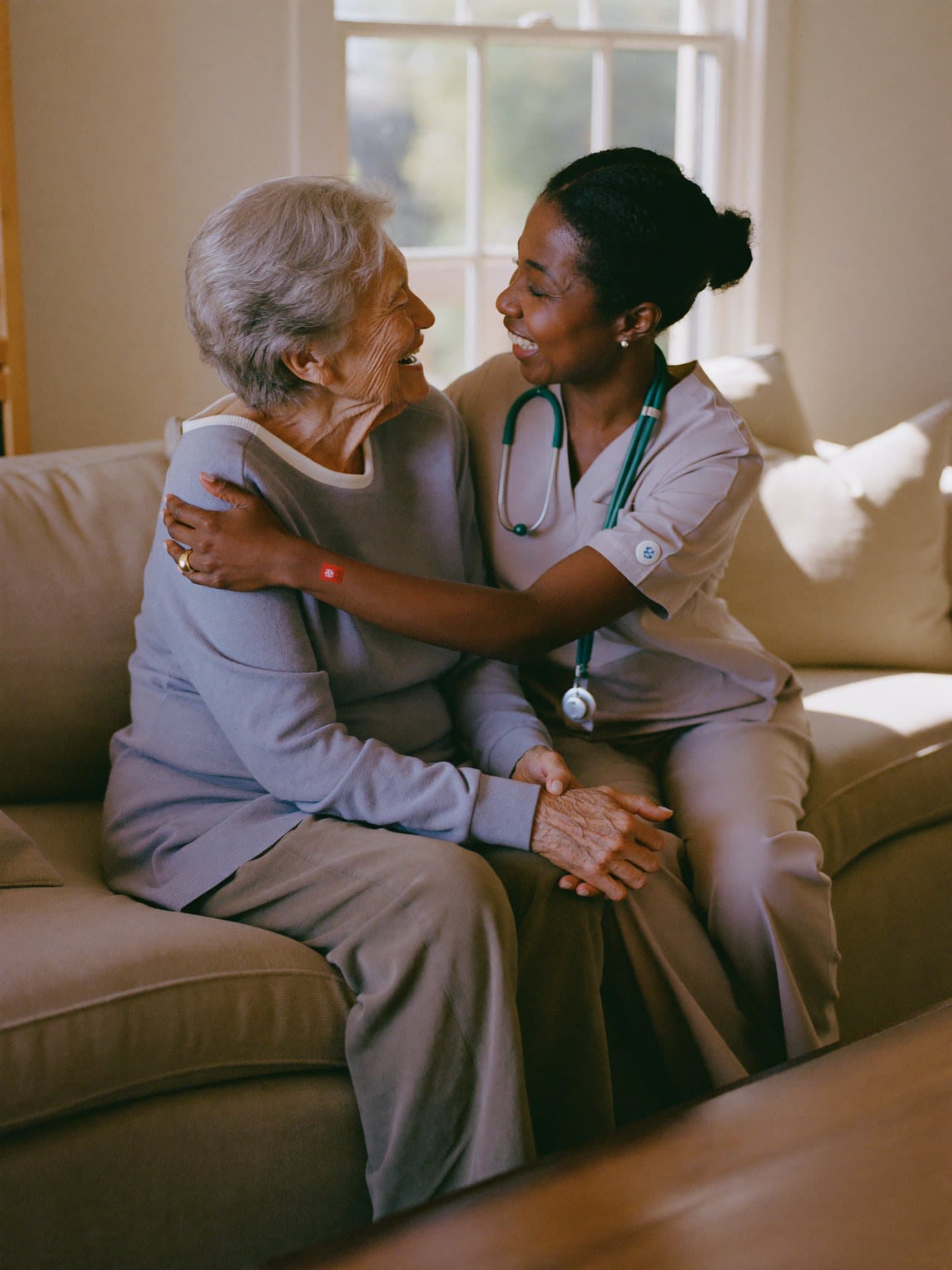 A Circles of Life caregiver sharing a warm, joyful moment with a senior client at home